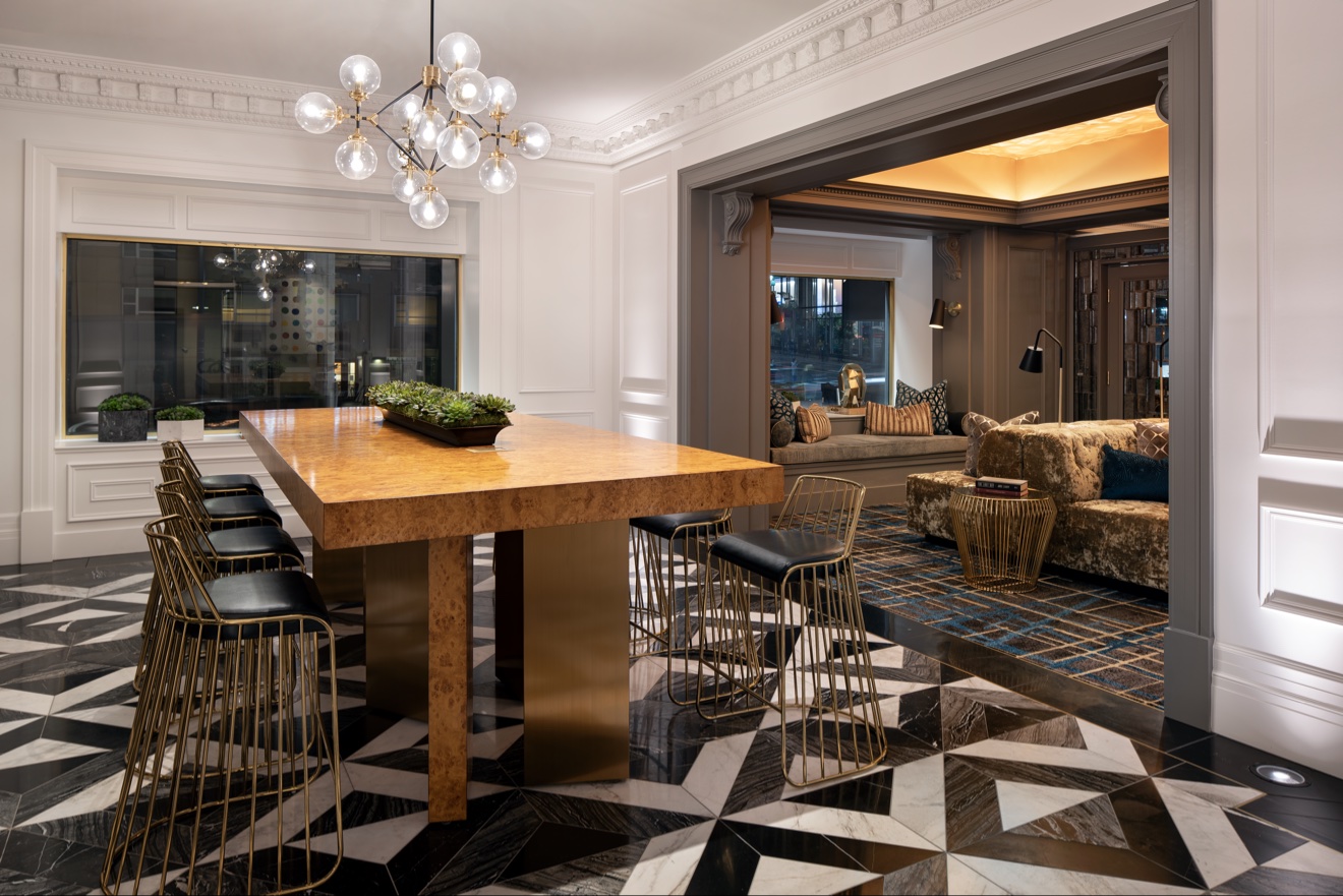 Communal lobby table beneath a crystal chandelier