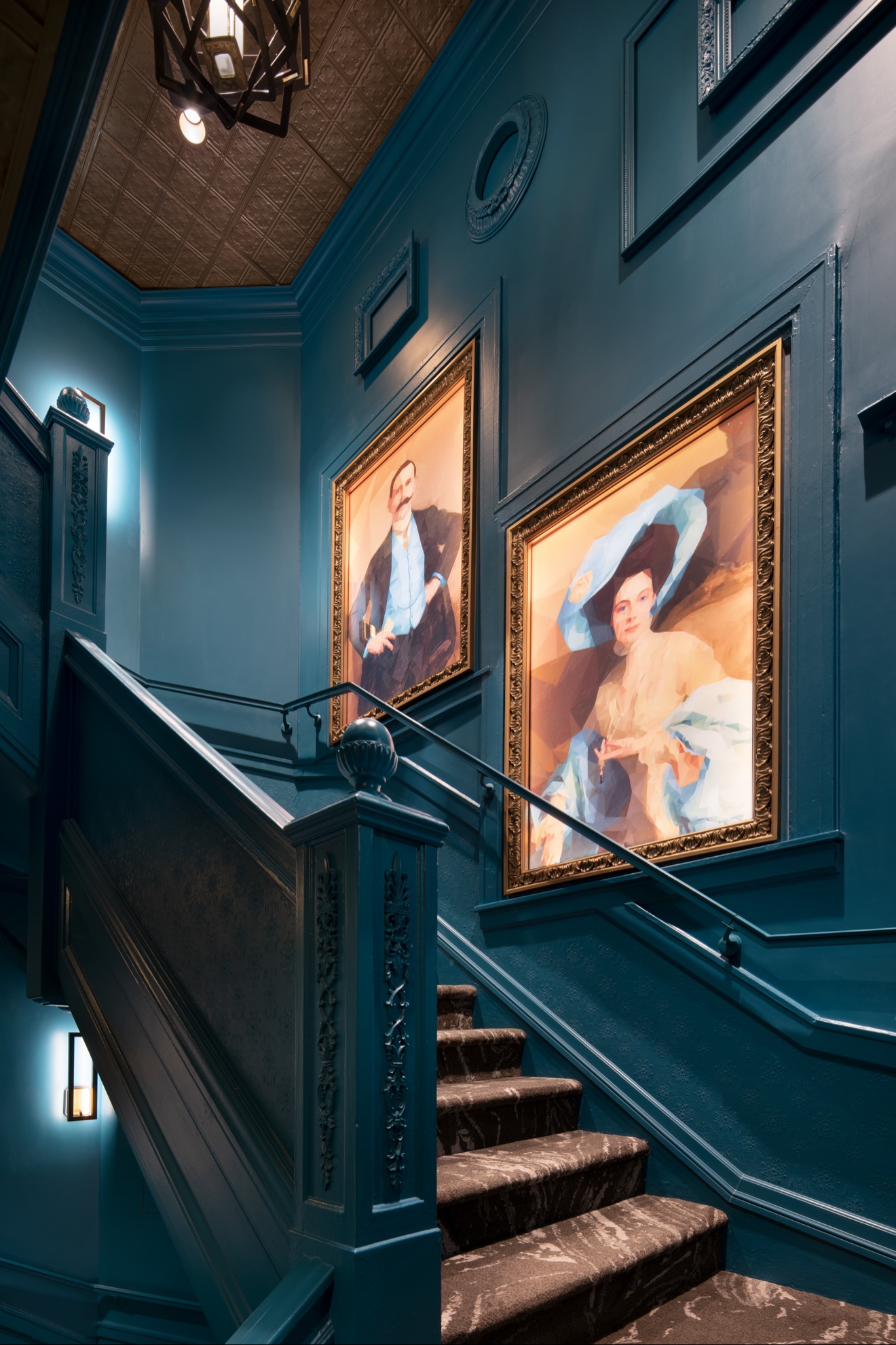 Framed portrait art in a dramatic teal stairwell