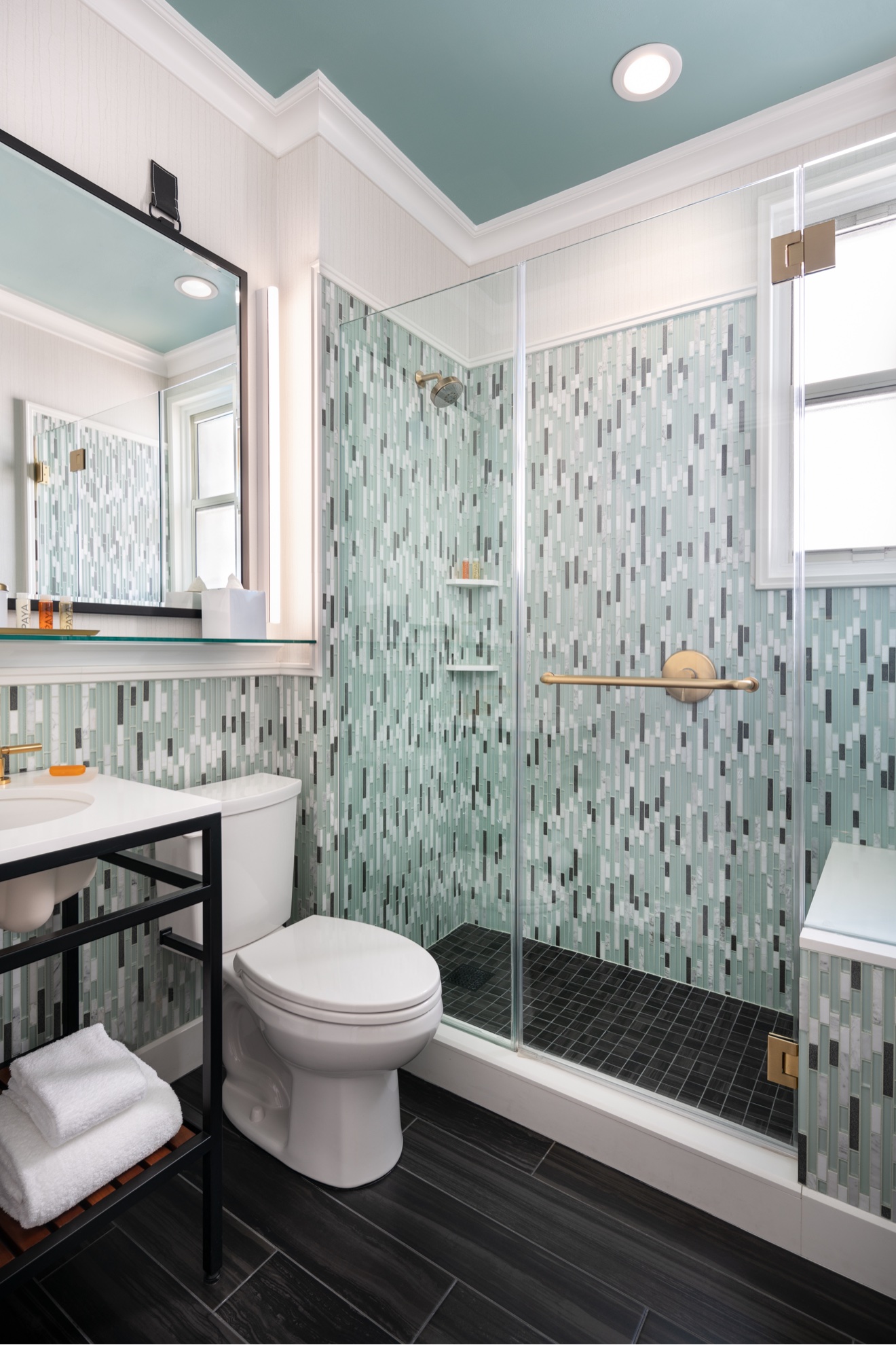 Guest bathroom with pale blue mosaic tile and glass shower