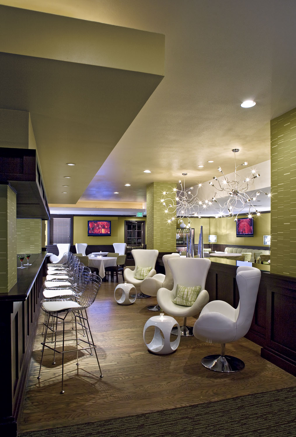 Tall restaurant interior with a patterned floor and illuminated shelving