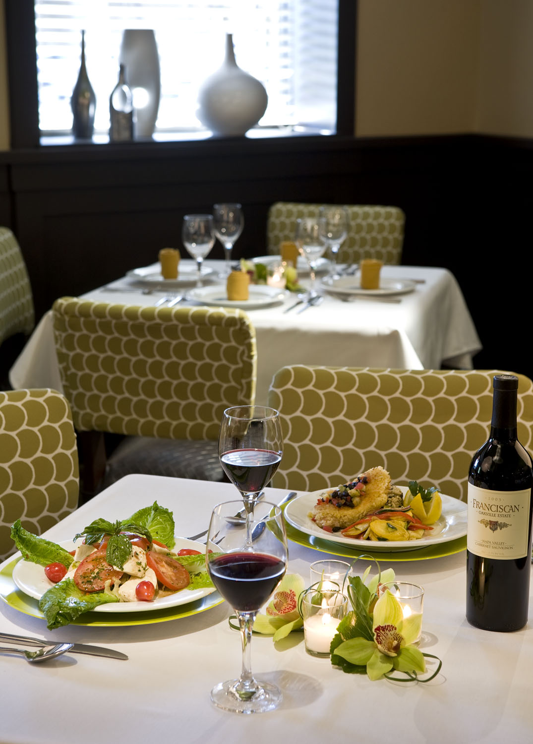 Dining room beside broad windows with a prepared buffet table