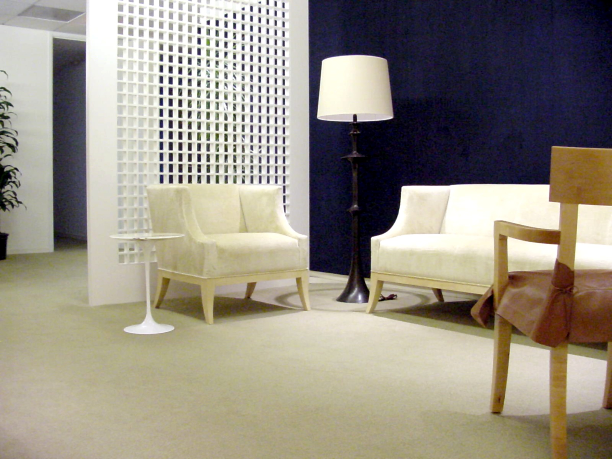 Entravision lounge with white seating, a floor lamp, and a gridded screen