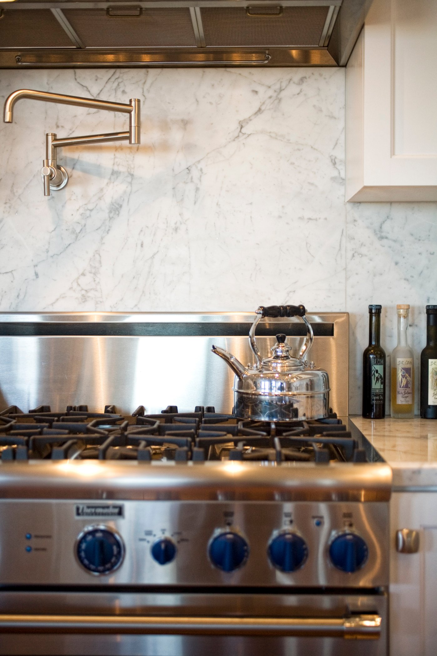 Green Street B Residence white kitchen with a professional range and dark countertop
