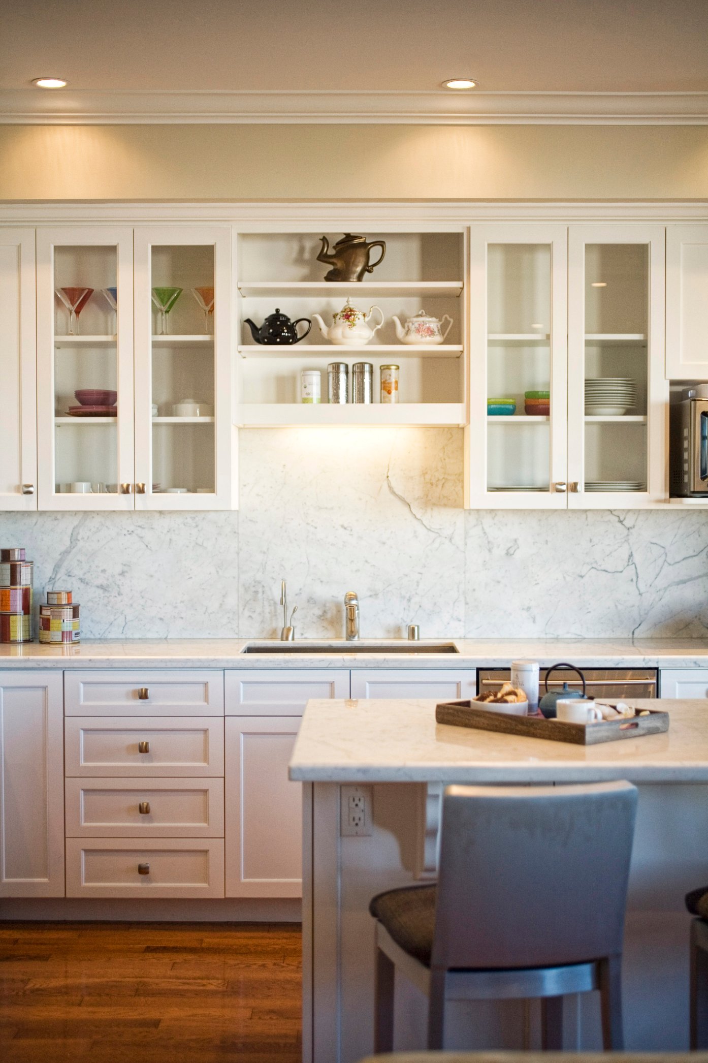 Green Street B Residence white kitchen with an island and glass-front cabinetry