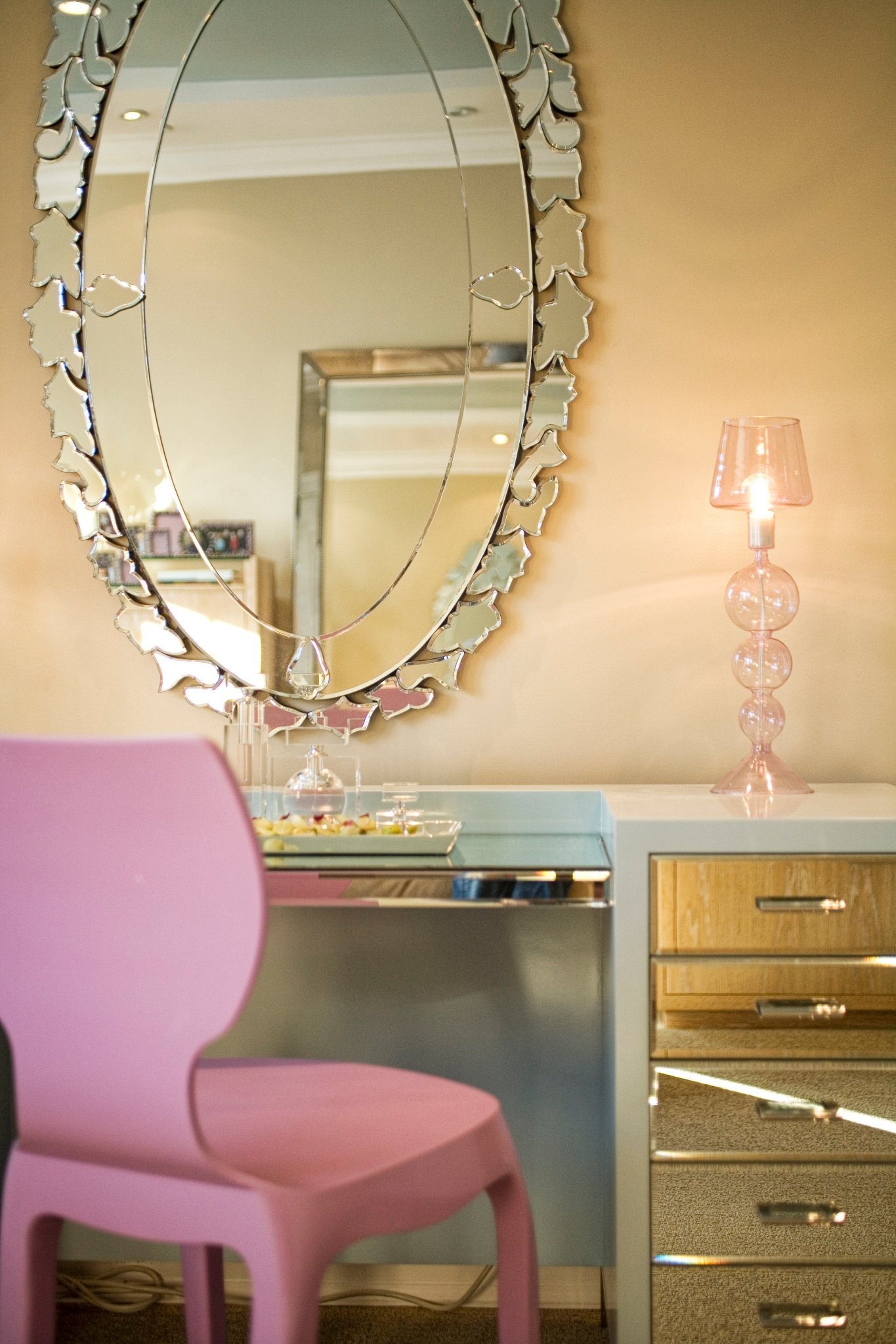 Green Street B Residence vanity area with an oval mirror and upholstered stool