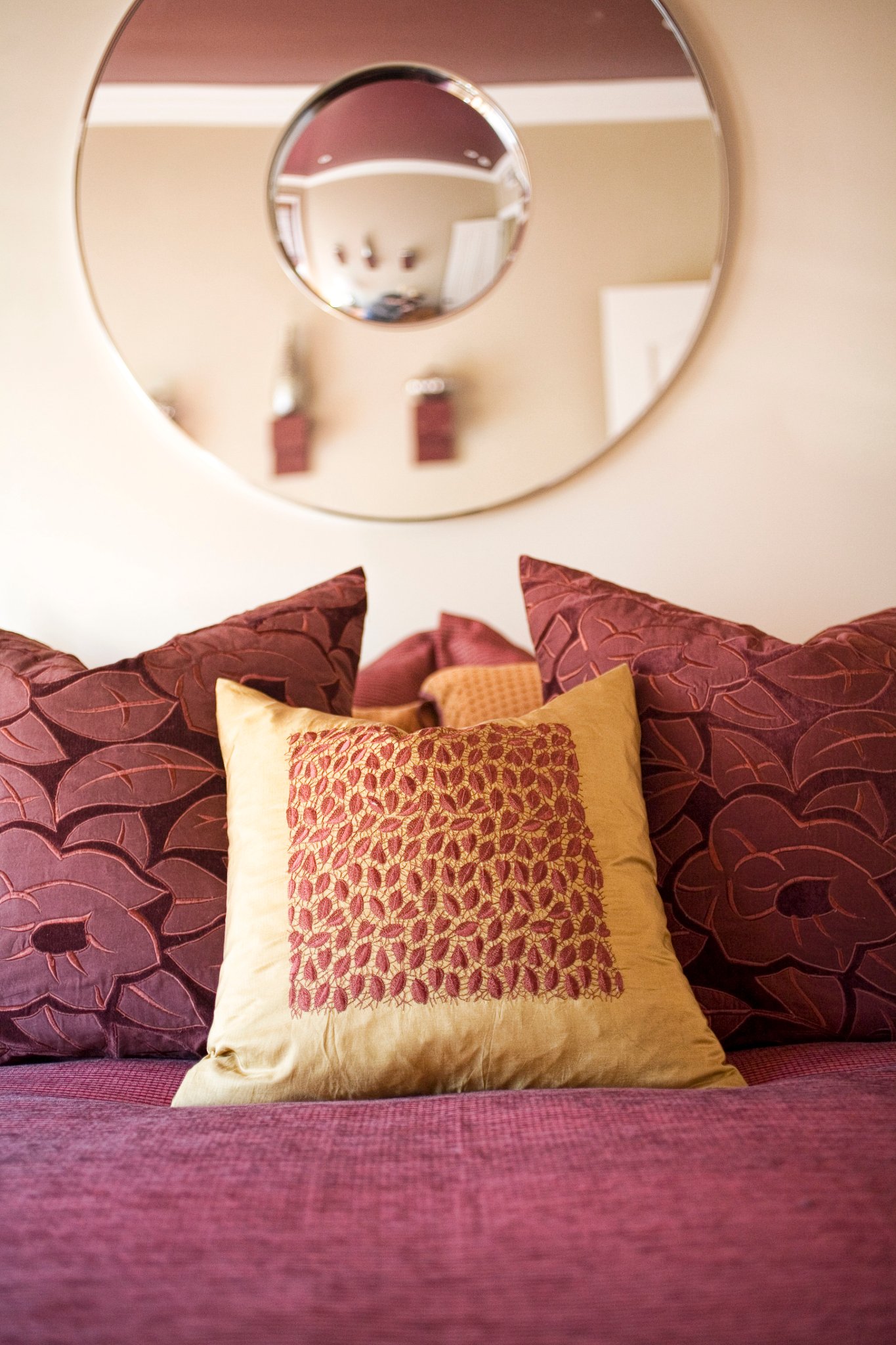 Green Street B Residence bedroom with a burgundy headboard and patterned textiles