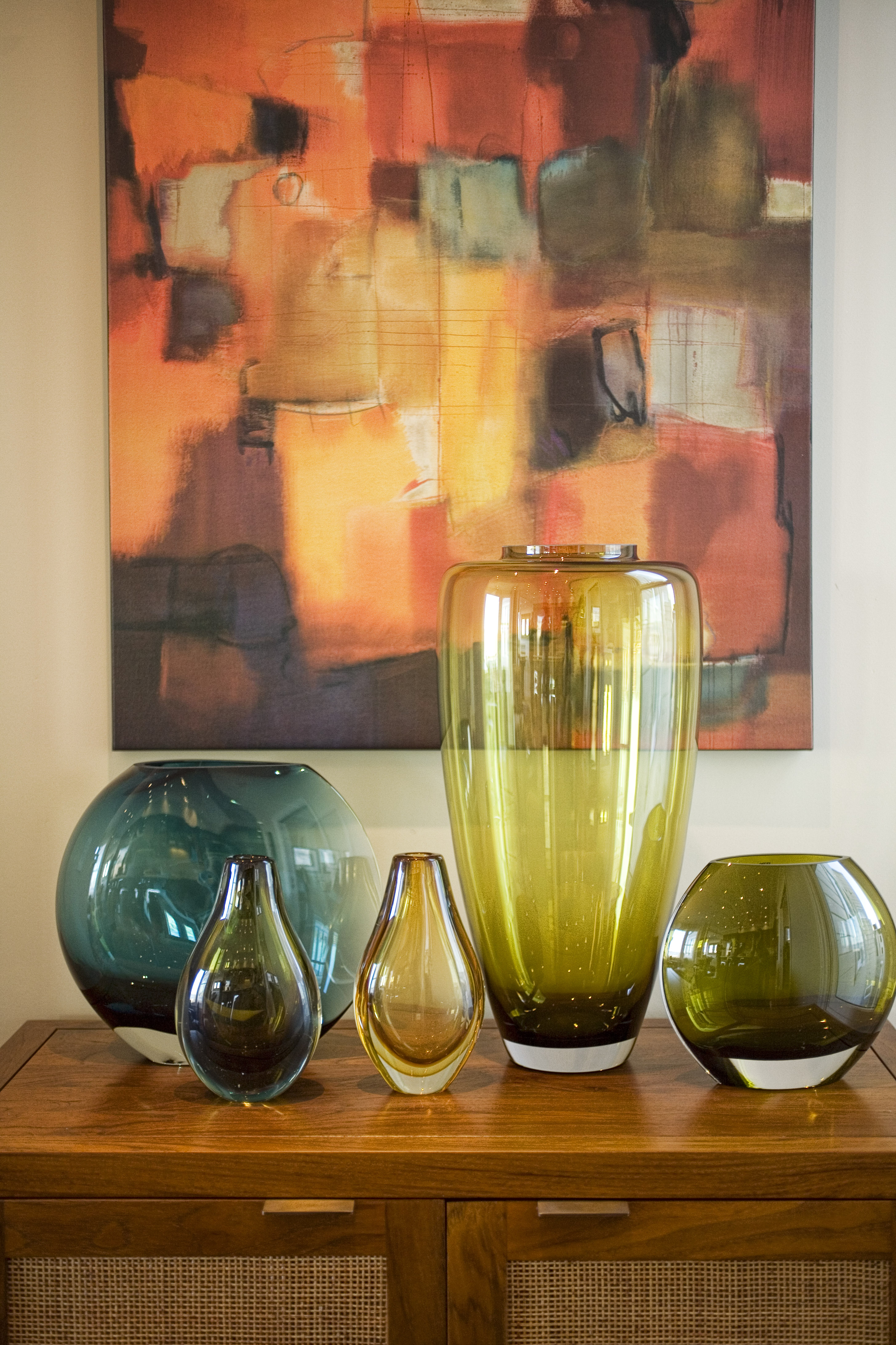 Green Street A Residence collection of glass vases beneath colorful artwork