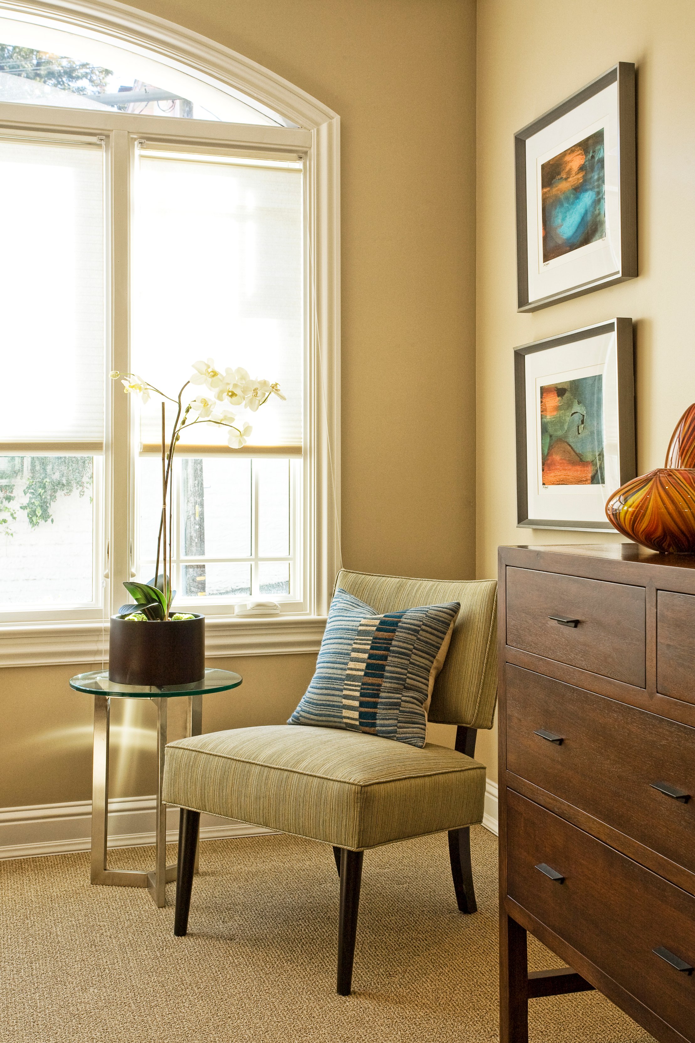 Green Street C Residence upholstered chair beside a window and dresser