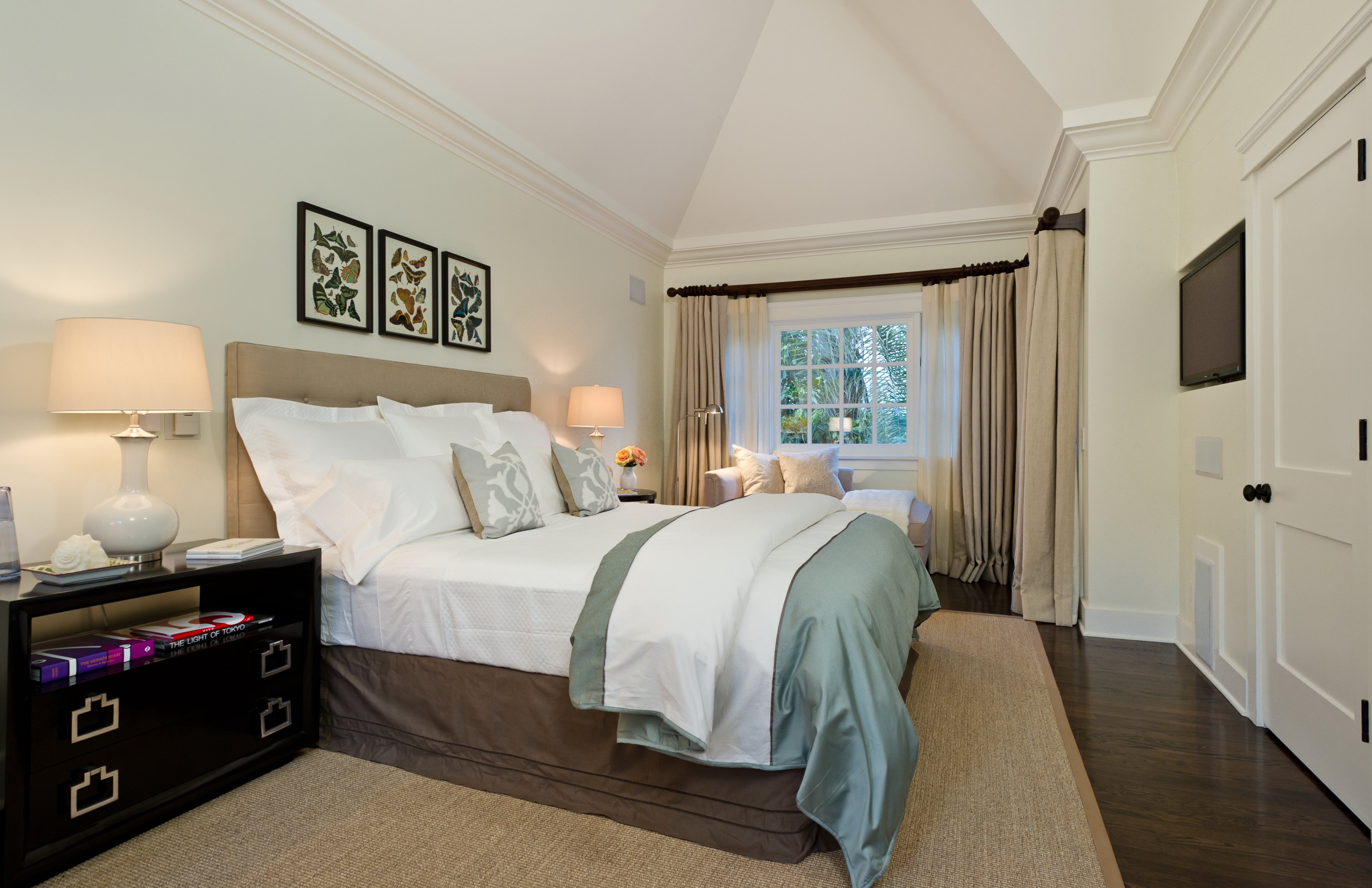 Serene bedroom with a vaulted ceiling, window seat, and soft blue accents
