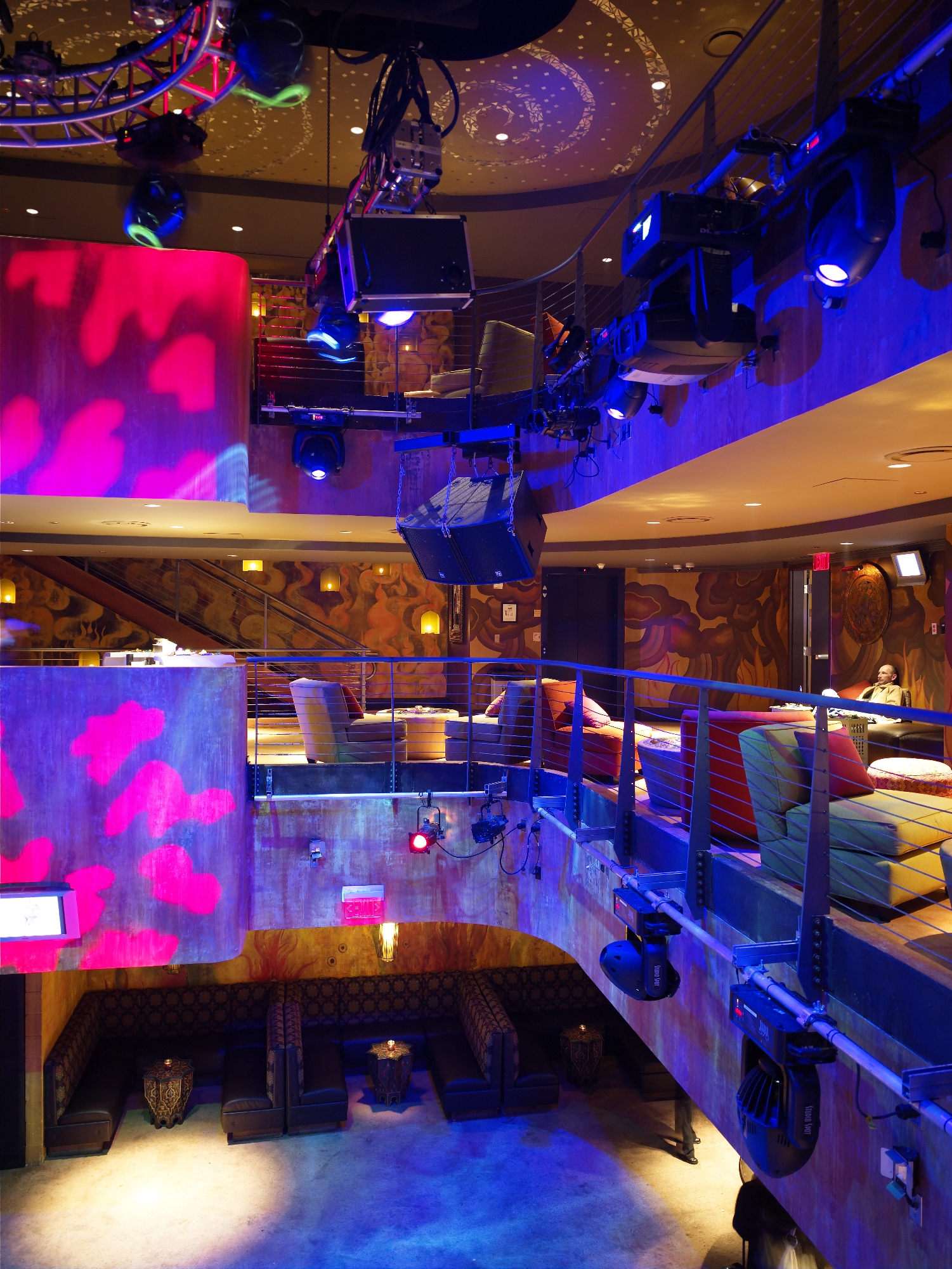 Multi-level nightclub interior with glowing screens and balcony lounges