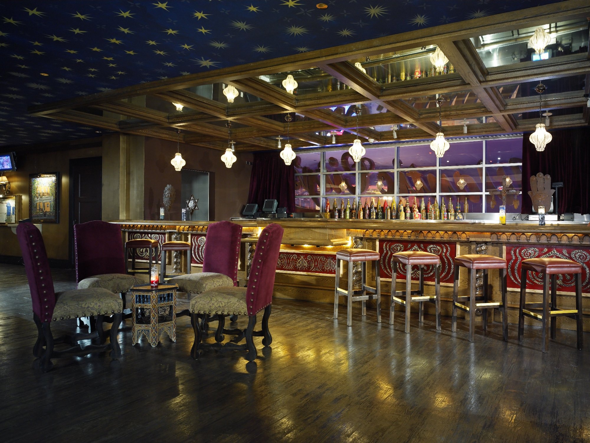 Nightclub bar with mirrored ceiling panels and eclectic furnishings