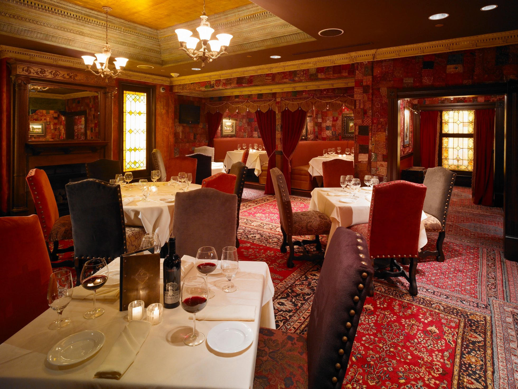 Foundation Room dining room with chandeliers, drapery, and richly patterned walls