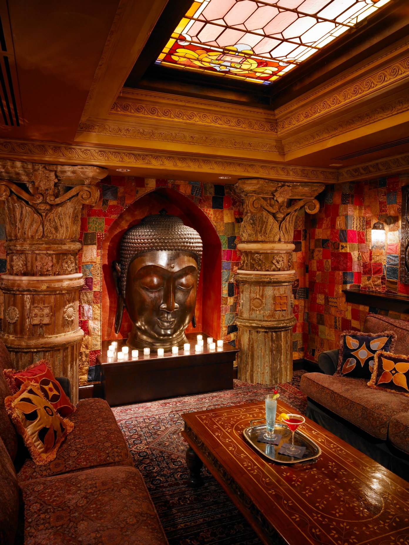 Buddha lounge with carved stonework, stained glass, and a fireplace