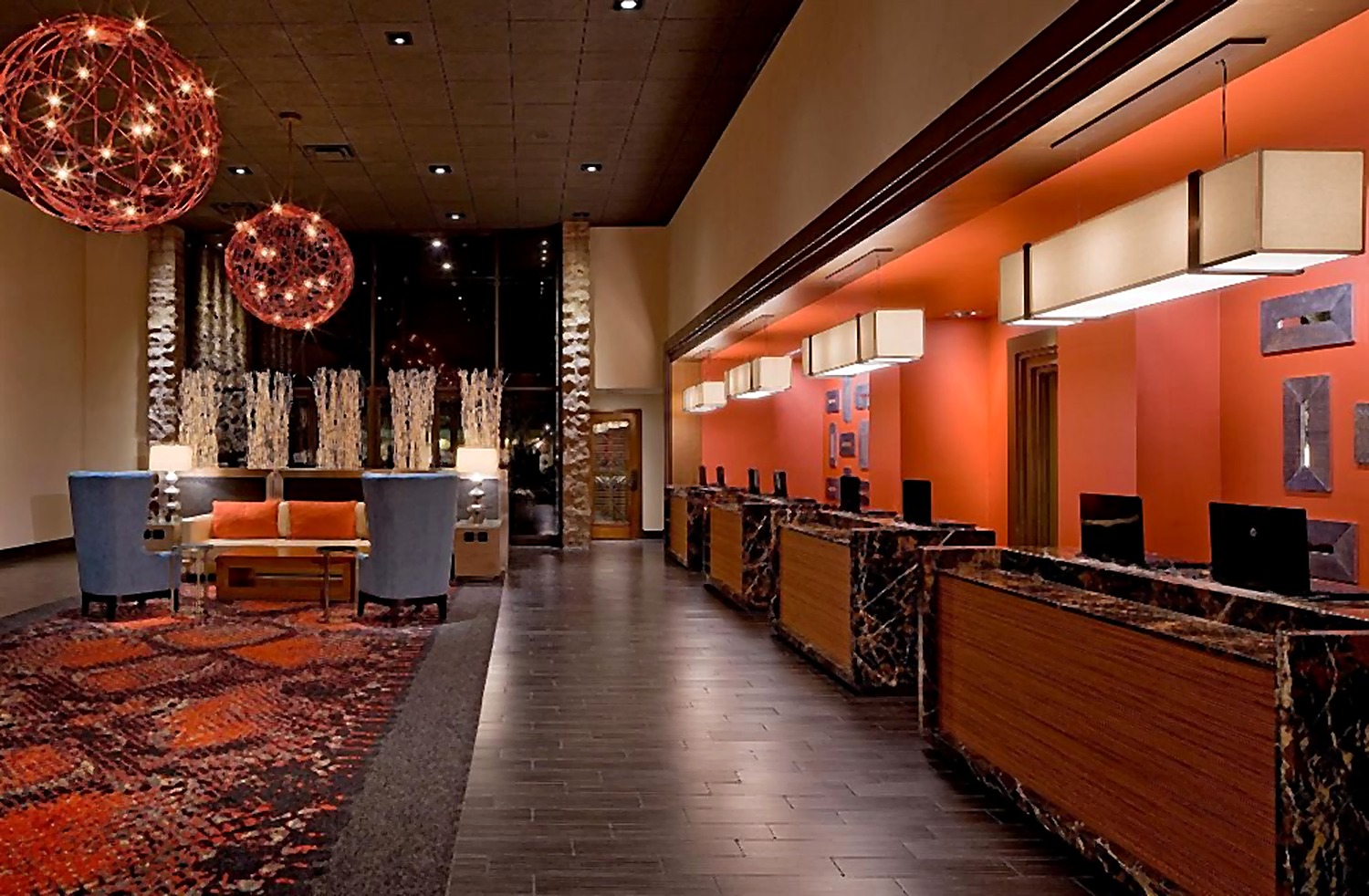 Hyatt Hotel front desk with warm woodwork and sculptural pendant lights