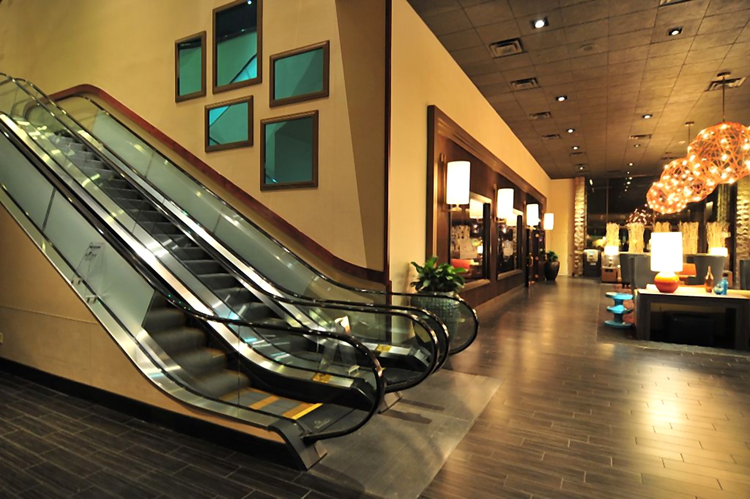 Hyatt Hotel lobby escalators beside framed artwork and warm pendant lighting