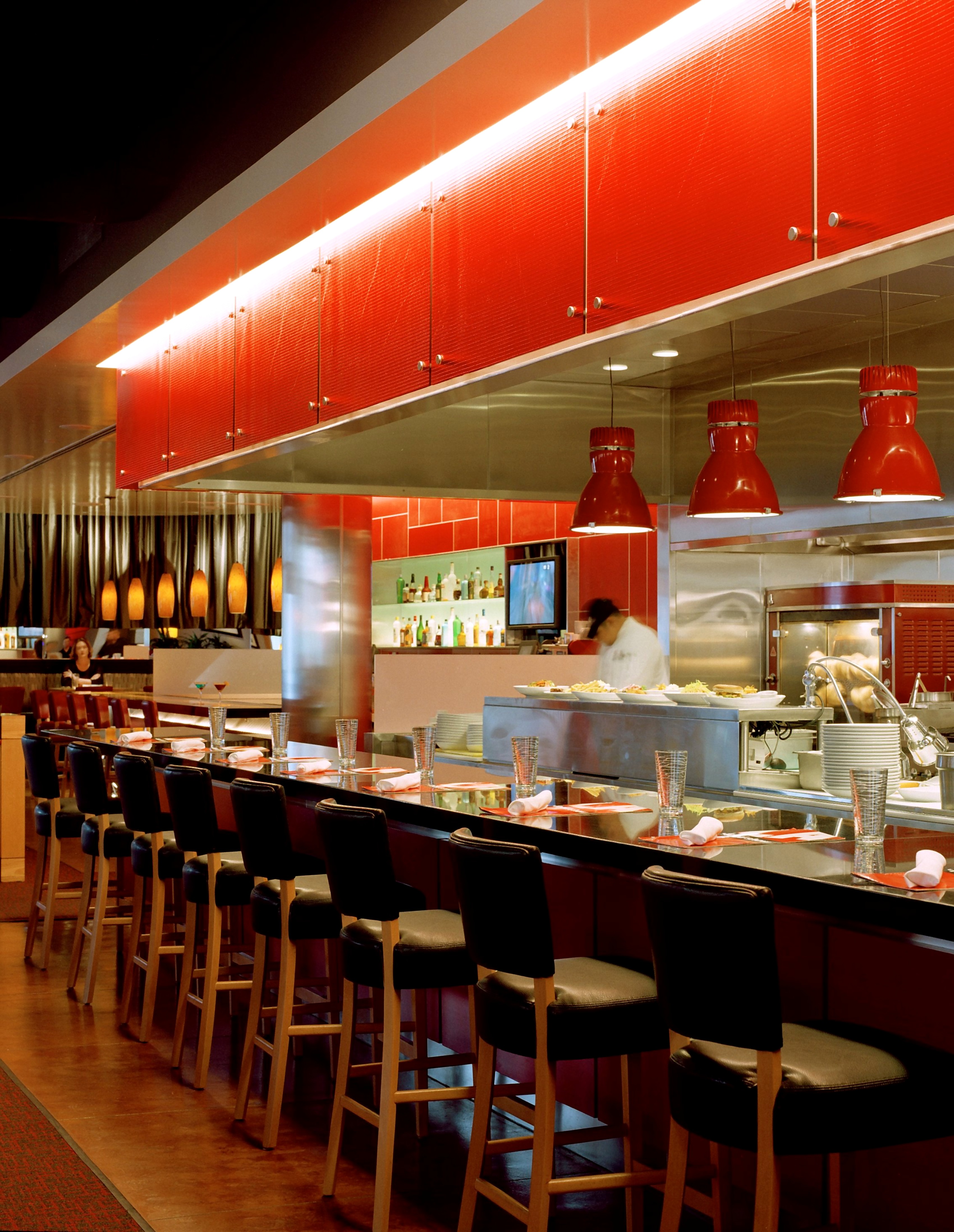 LA Food Show open-kitchen counter with red millwork and black stools