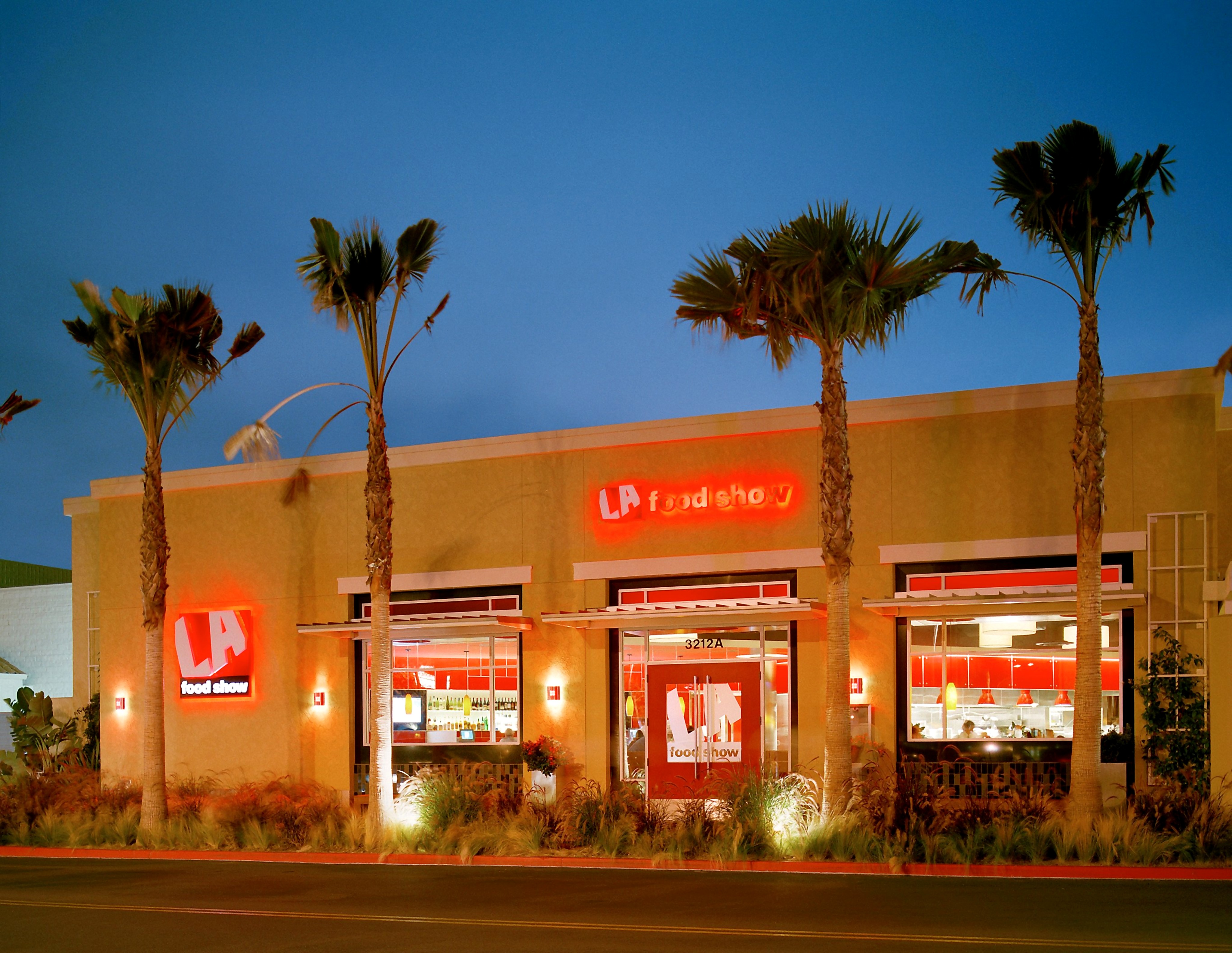 LA Food Show restaurant exterior at dusk with palm trees