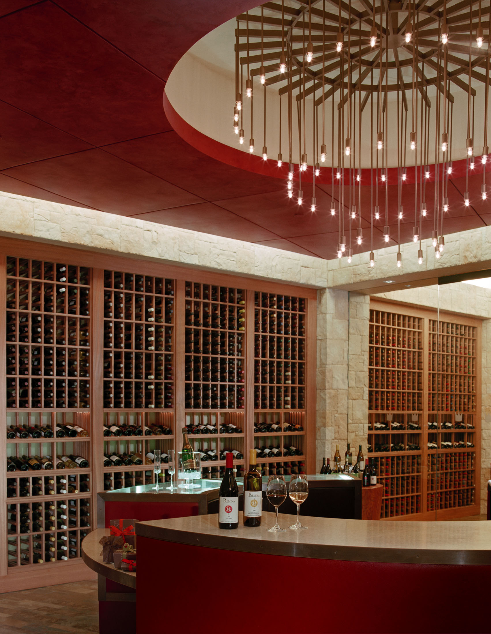 Le Chateau at The Beverly Hilton wine cellar with floor-to-ceiling bottle storage and a sculptural chandelier