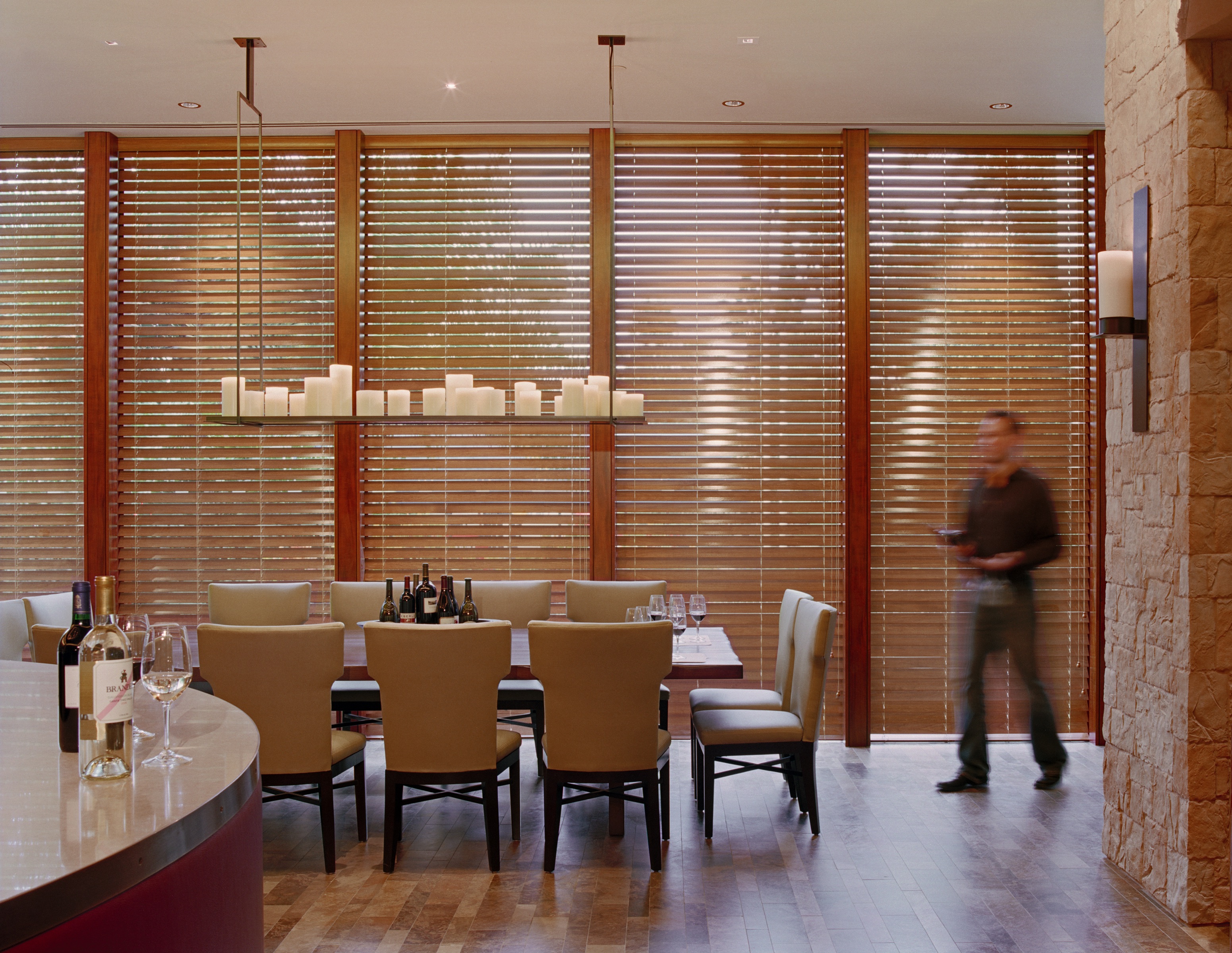 Le Chateau dining room with a long tasting table and wood-slat window screens