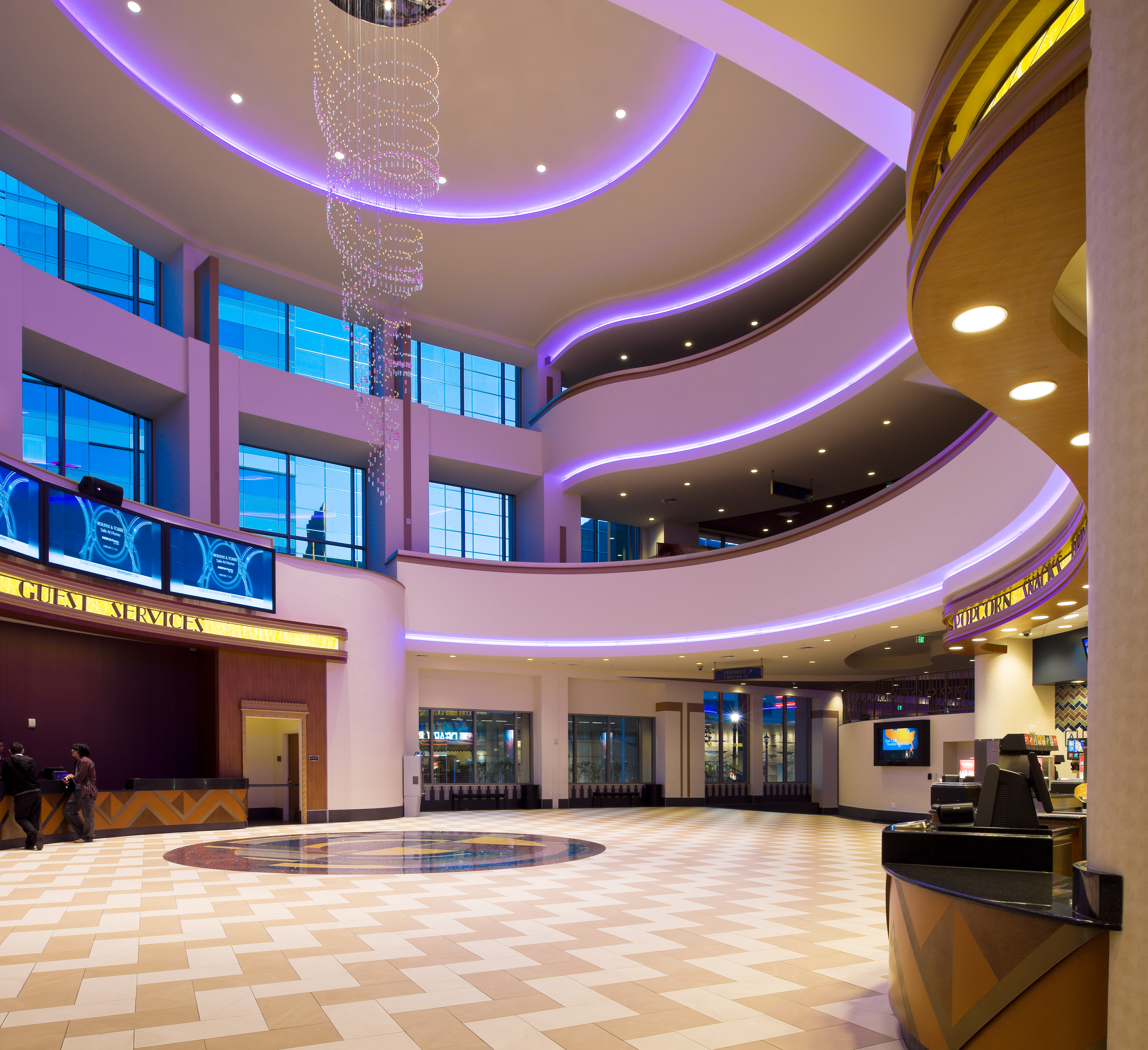 Lobby with curved balconies, purple cove lighting, and a checkerboard floor