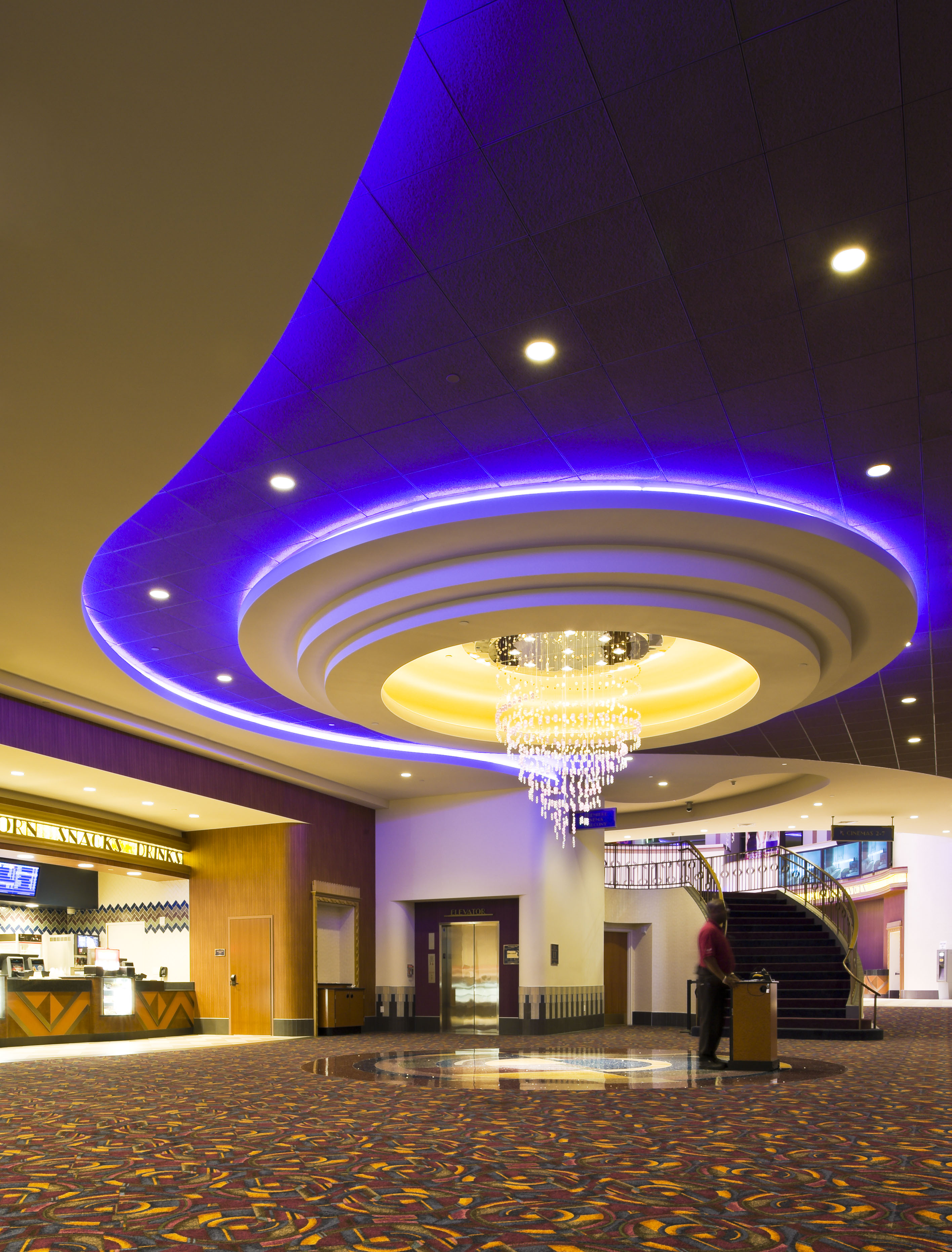 Lobby with a circular ceiling medallion, chandelier, and grand staircase