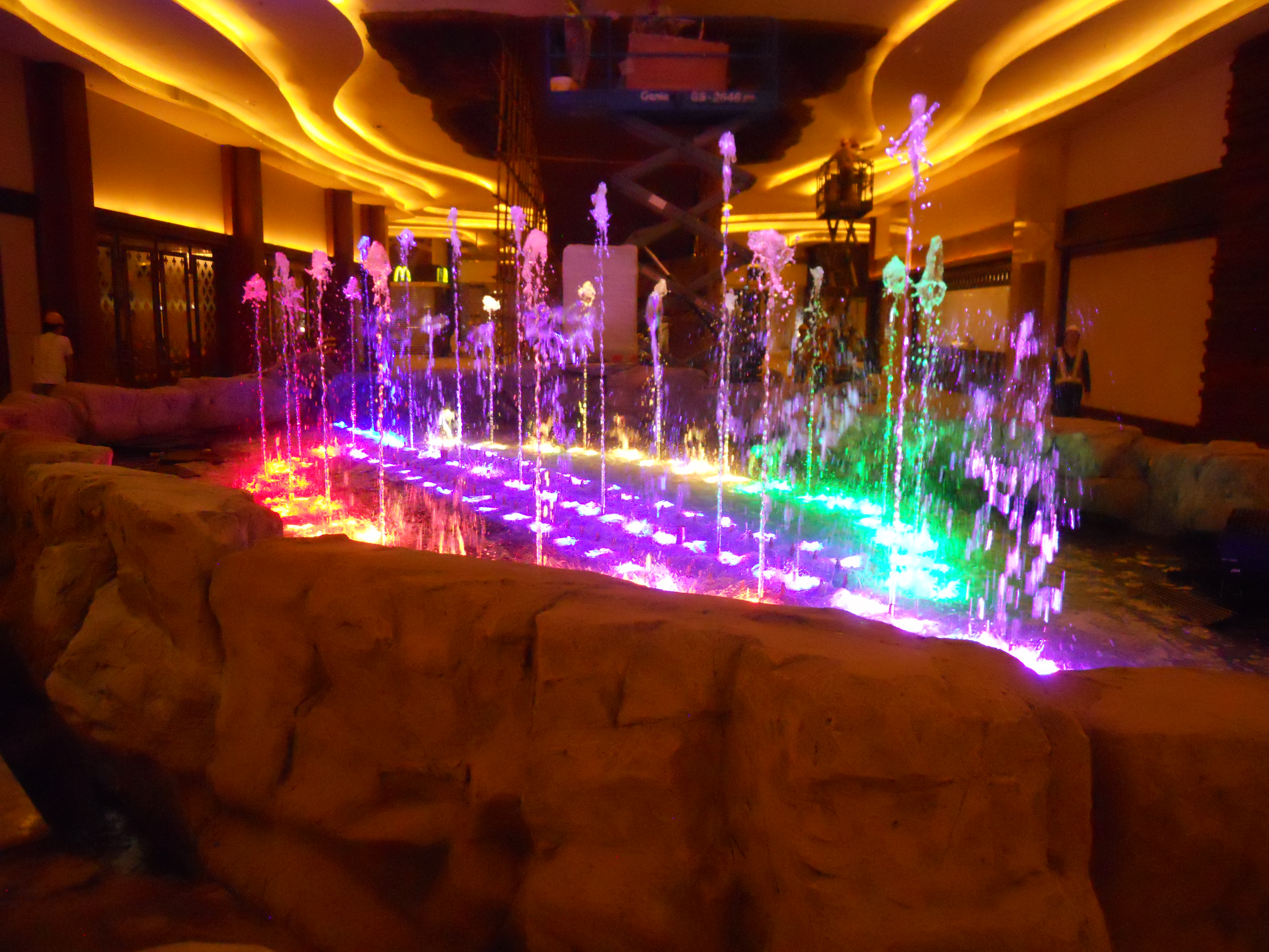 Illuminated fountain with colored lights playing over a rock formation