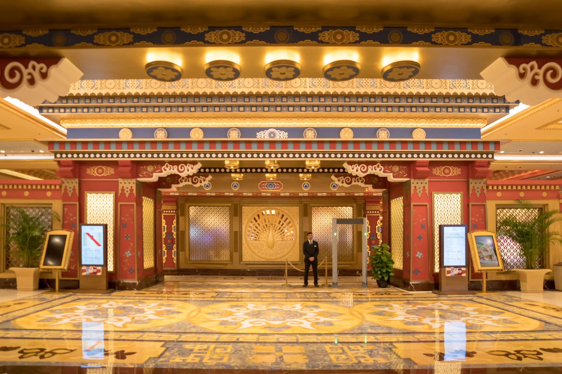 Ornate entrance hall with Tibetan-inspired painted detailing and a patterned stone floor