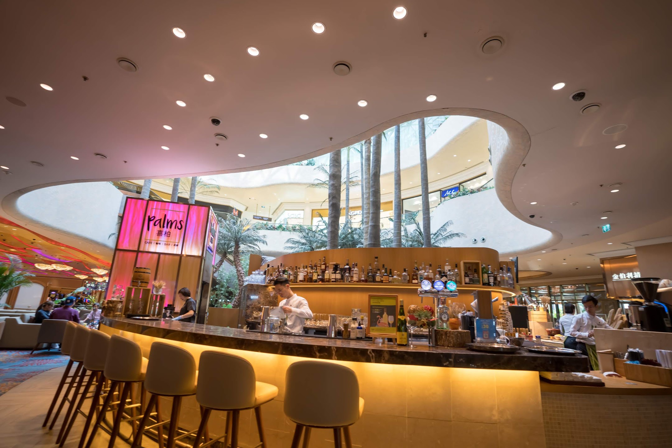 Bar lounge with a curved counter beneath a sculptural ceiling