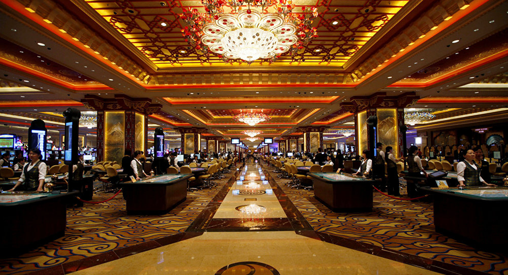 Casino hall with a crystal chandelier and rows of gaming tables