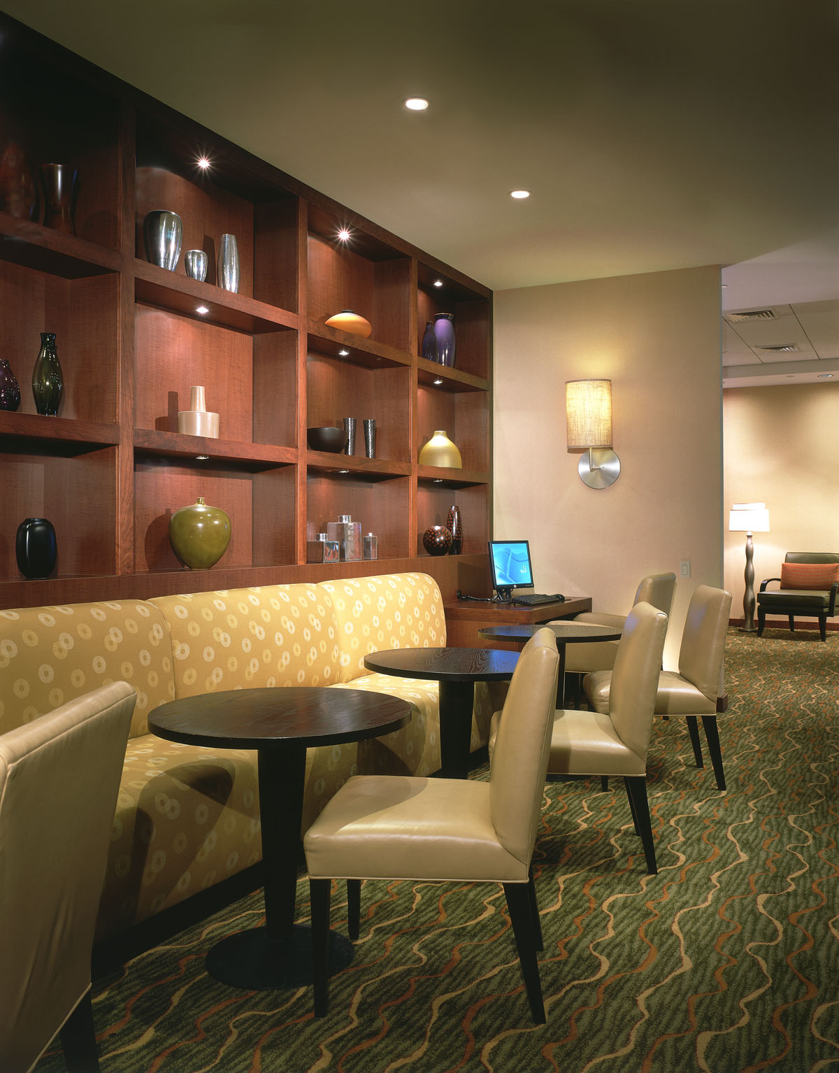 Lounge seating beside built-in walnut shelving with decorative vessels