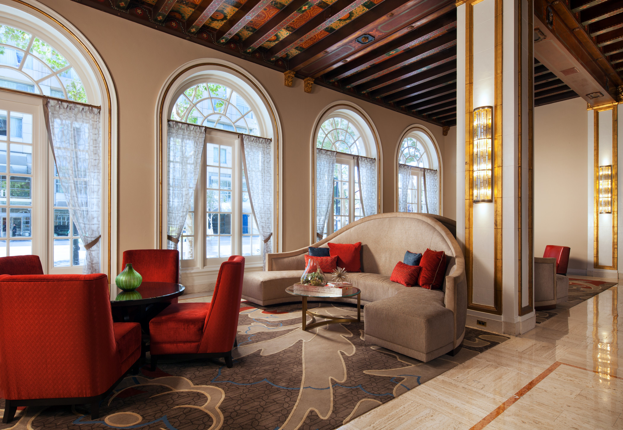 The Westin St Claire lobby with arched windows, red accents, and wood-beamed ceiling