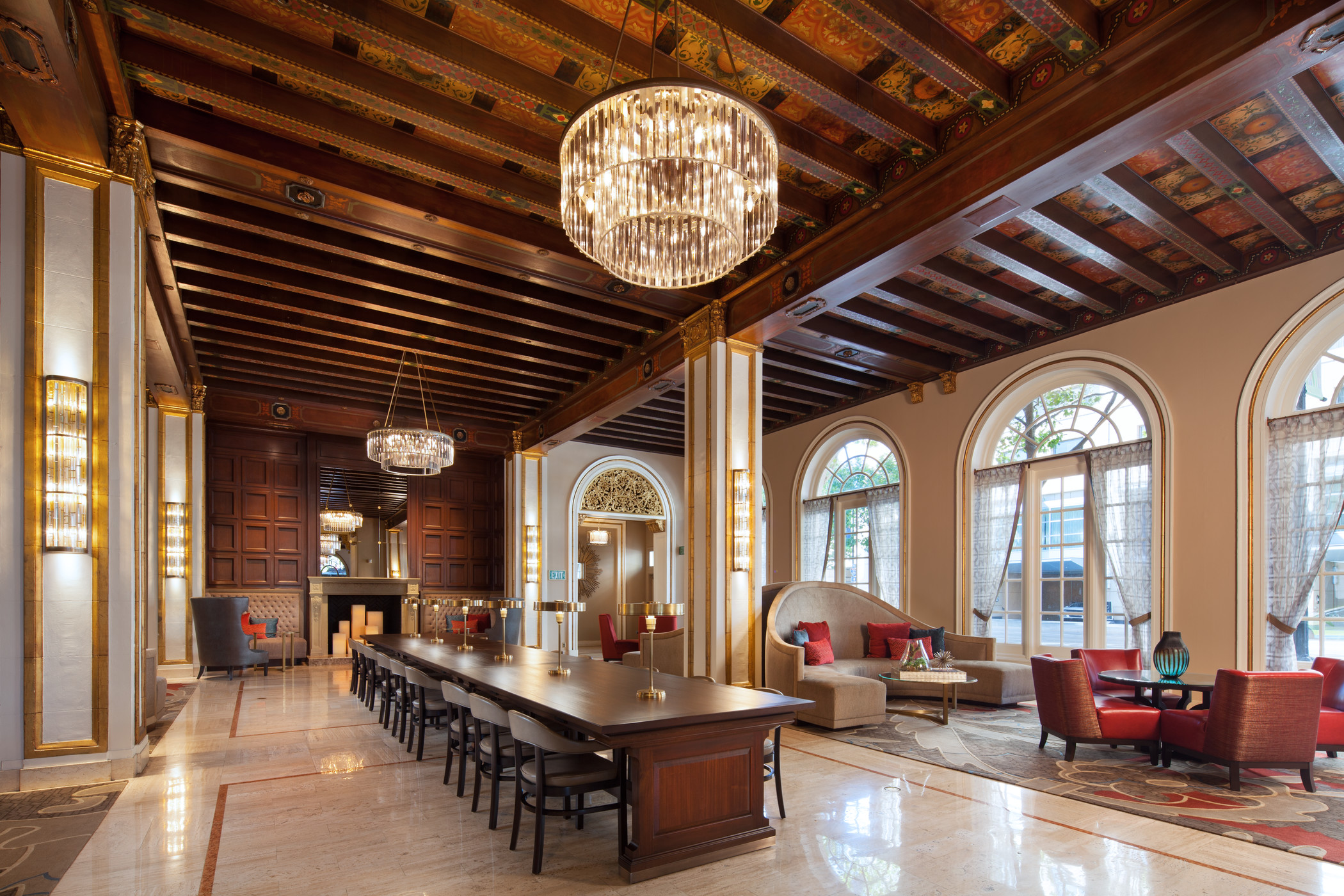 The Westin St Claire grand lobby with arched windows, a long central table, and crystal chandeliers